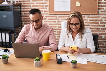 Wall Mural - Man and woman business workers using laptop and smartphone at office