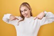 © Krakenimages.com - Young caucasian woman wearing white sweater over yellow background looking confident with smile on face, pointing oneself with fingers proud and happy.
