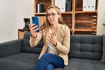 Wall Mural - Young blonde woman psychologist having online mental consultation at psychology clinic