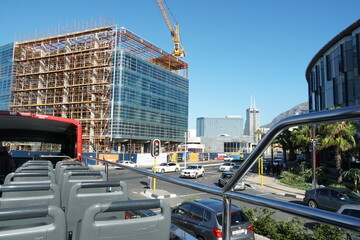 City center of Cape Town with modern building under construction from top of double decker hop on hop off tourist bus during sunny summer day..