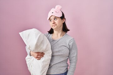 Canvas Print - Woman with down syndrome wearing sleeping mask hugging pillow smiling looking to the side and staring away thinking.