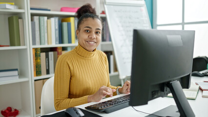 Young african american woman student using computer studying at the library