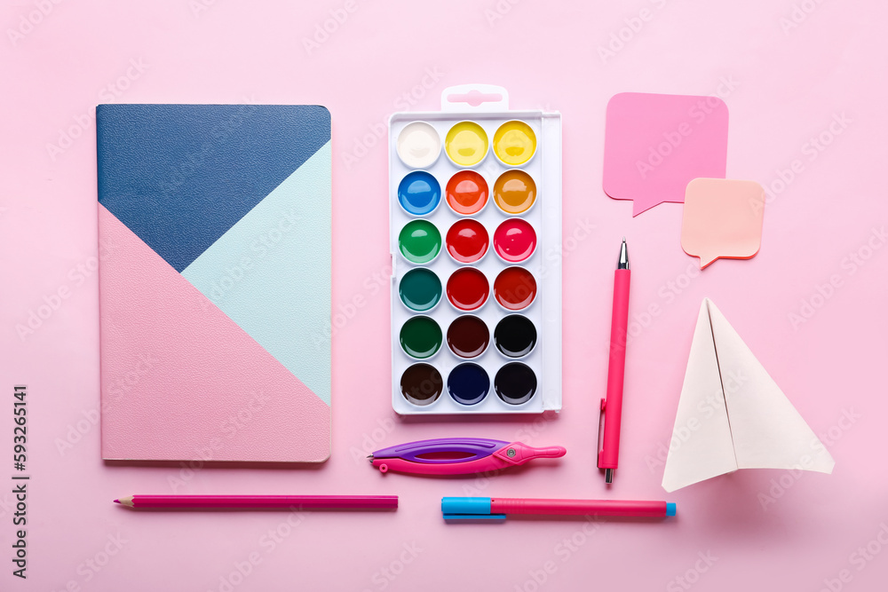 Composition with stationery supplies and paper plane on pink background
