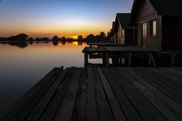 Poster - Line off wooden houses on a lake during the sunset