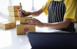 © Tj - startup girl Small SME business owners work with laptop computers at work. with parcel paper boxes for delivery to customers online selling, Ecommerce,
