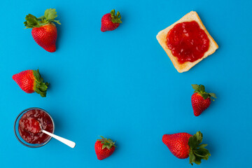 Wall Mural - A top view of the strawberry jam-filled bread and strawberry fruit isolated on blue