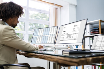 Poster - Looking At Invoice And Spreadsheet On Computer