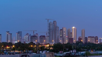 Canvas Print - Time lapse of tall skyscrapers against the sky with the daytime changing into evening