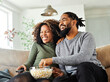 © Lumos sp - television watching couple tv home woman man remote movie entertainment sofa lifestyle sitting fun popcorn happy young smiling female happiness love leisure together