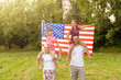 © Angelov - happy family with the flag of america USA at sunset outdoors