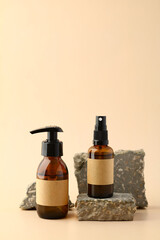 Wall Mural - amber glass bottles on stone podiums on beige background. natural spa cosmetics.