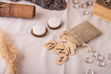 Fototapeta Sypialnia - Handmade cardboard Scandinavian divination runes fall out of the pouch on the table