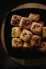 Poster - Vertical top view of homemade black sesame scones placed on a plate