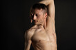 © vladorlov - Adult attractive man with a beautiful body posing in the studio. Black background.