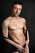 © vladorlov - Adult attractive man with a beautiful body posing in the studio. Black background.