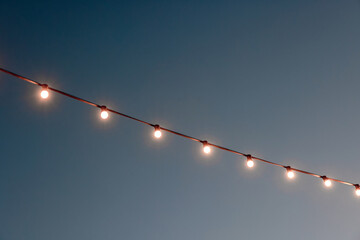 Wall Mural - light bulbs garlands against sky