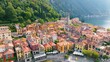 Aerial view of Varenna, Lake Como, Italy. Flying over orange roofs of old town with the church of San Giorgio in the central square