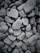 Decorative pebbles for the garden in shades of gray and black. Stone background.
