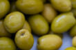 Green olives on a white background. Close up. Select focus.
