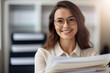 © aicandy - Close-up portrait of a beautiful and trustworthy loan officer with a friendly smile and a stack of financial documents in her hand, generative ai