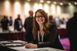 © aicandy - Portrait of a dedicated and hardworking meeting and convention planner, standing in front of a busy event registration desk and assisting attendees with a warm smile, generative ai