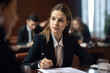 © aicandy - Young legal secretary sitting at a conference table, taking notes during a meeting with lawyers, wearing professional attire and a serious expression, generative ai