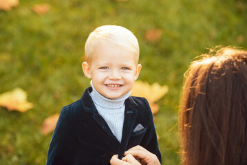 cute little smiling happy boy in suit. portrait of kid outdoors. close-up face child playing outdoor