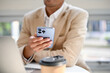 © bongkarn - A millennial Asian businessman using his smartphone while relaxing in a cafe.