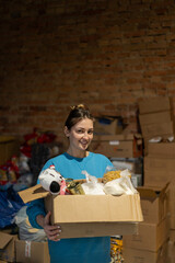 Volunteer girl preparing donation boxes for people. Donation clothing for refugees, support of war victims. Humanitarian aid concept.Helping people