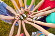 © Studio Romantic - Group of children standing close in circle joining their hands. Top view of boys and girls showing thumbs up. Team joining hands celebrating victory, unity and collaboration concept