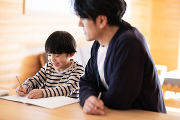 Wall Mural - 勉強をする男の子と見守る父親