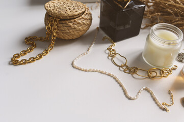 Minimalist home aesthetics. Fashion jewellery and candles setting on white background. Feminine trendy home