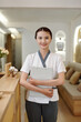 © DragonImages - Portrait of positive beauty salon receptionist holding documents folder