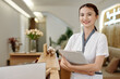 © DragonImages - Portrait of smiling spa salon receptionist with documents folder