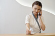 © DragonImages - Beauty salon receptionist talking on phone with client and checking schedule