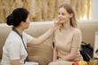 © DragonImages - Cosmetologist touching face of young woman