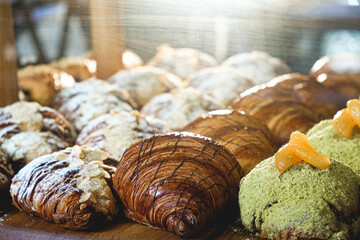 Wall Mural - Variety of fresh bunsdesserts and cake, behind the shop window. Fresh delicious pastries, croissants.Bakery concept
