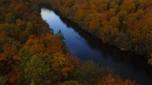 Aerial Of A Small Kayak In The Calm River Surrounded By The Yellow Autumn Forest