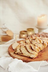 Sticker - Vertical shot of a delicious nut cake with cream on a wooden plate with white background