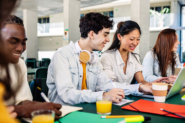 Wall Mural - Multiracial college students preparing exams sitting together at cafeteria. Education lifestyle concept