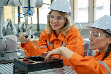 Aufkleber - Female industrial engineer or technician working and inspecting robotic arm machine at manufacturing plant.