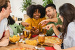© PintoArt - laughing friends eating pizza and having fun. They are enjoying eating and drinking together. they look at the smart phone laughing watching videos of social networks
