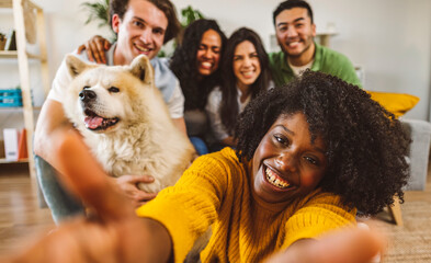 Wall Mural - group of multiracial friends on sofa home making selfie photo, posing together with dog, lifestyle concept - focus on african american woman -