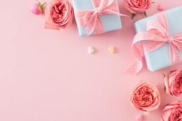 Wall Mural - Happy Mother's Day concept. Top view composition of gift boxes with bows pink rose buds and small hearts on isolated light pink background with empty space