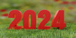 2024 Happy New Year red digit text on fresh green grass field background. Banner. 3d render