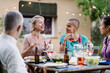 © EFStock - Female friends enjoying conversation together at summer dinner at home - Women having fun drinking and eating