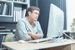 © Zuev Ali - An elderly woman is sitting at a computer.