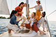© blackday - Group of happy friends drinking wine and relaxing on the sailboat during sailing in sea
