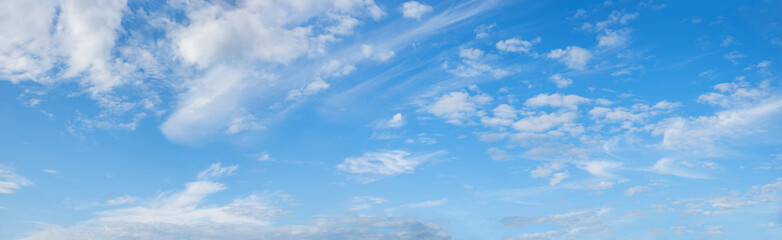 Wall Mural - wide blue sky background with cirrus and fleecy clouds, panorama format