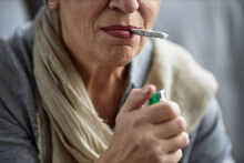 Closeup of adult woman lighting up cigarette smoking for therapeutic purpose and medical treatment